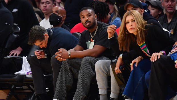 Michael B. Jordan sits courtside at an NBA game.